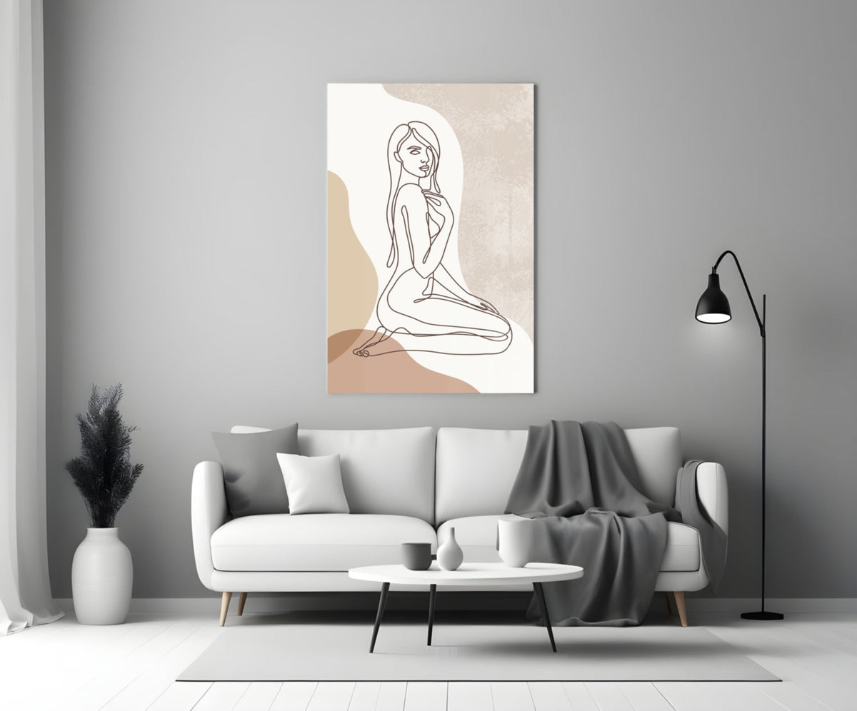 Kneeling woman line art glass wall art above a white sofa beside a black floor lamp