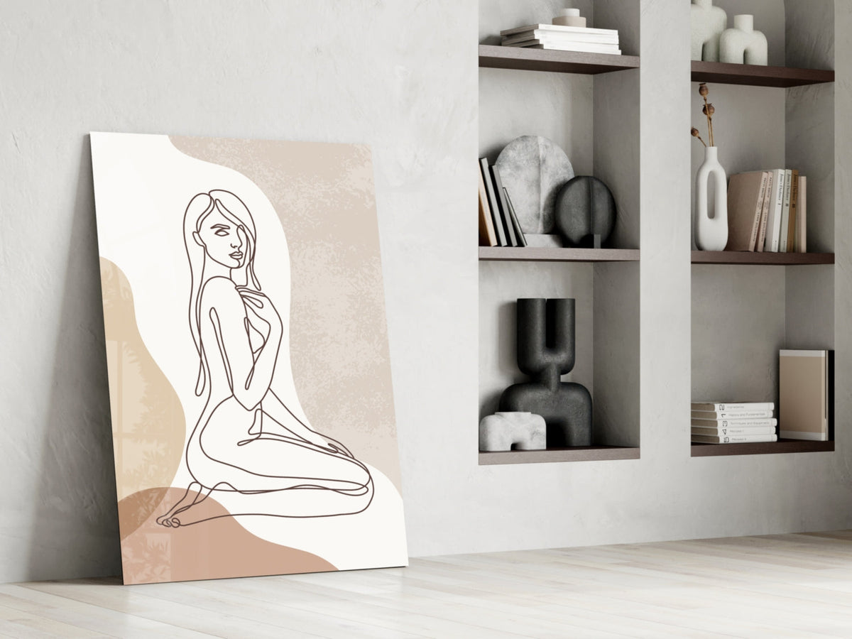Kneeling woman line art glass print leaning against a white wall beside open shelves