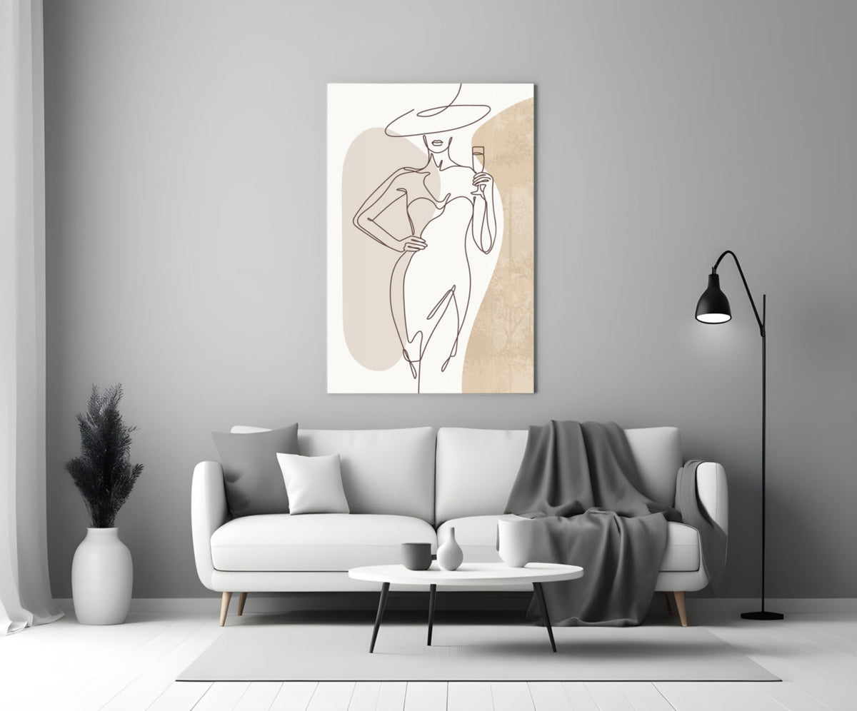 Wide hat line art woman glass wall art above a white sofa with a gray throw and a black floor lamp