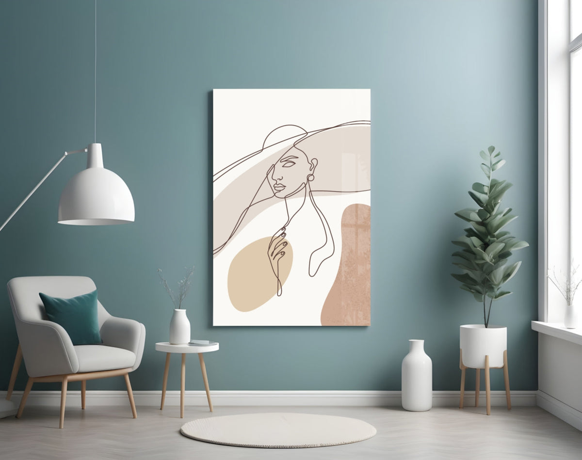 Sun hat line art woman glass wall art on a teal wall beside a white armchair and a white pendant lamp