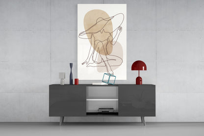 Seated woman line art glass wall art above a dark gray media console with a red lamp