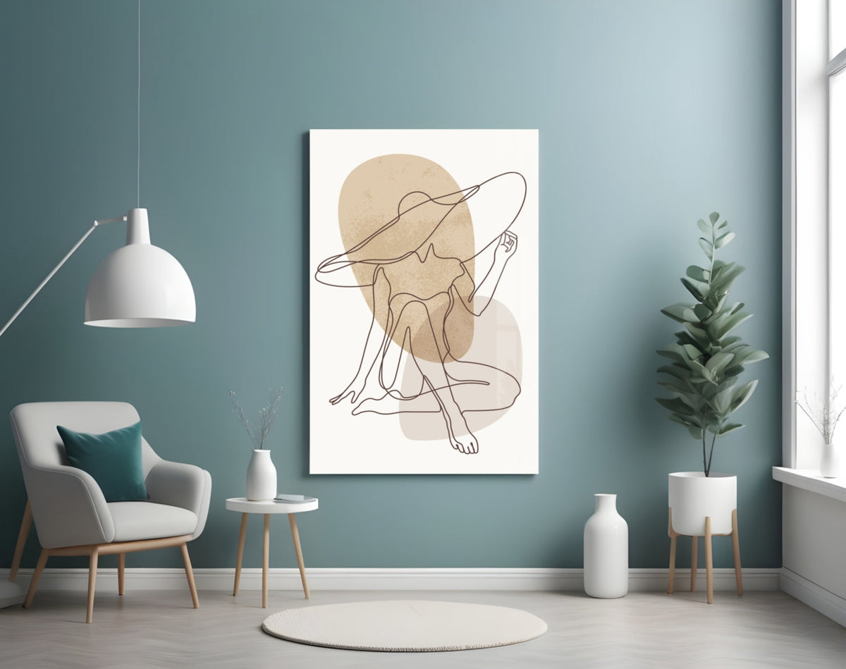 Seated woman line art glass wall art on a blue wall above a cream armchair and pendant lamp