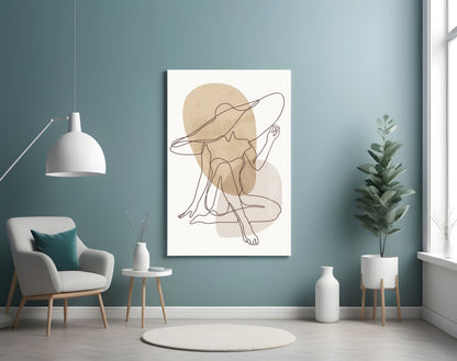 Seated woman line art glass wall art on a blue wall above a cream armchair and pendant lamp