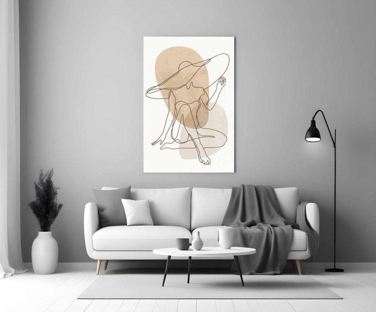 Seated woman line art glass wall art above a white sofa beside a black floor lamp
