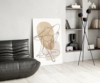 Seated woman line art glass print leaning beside a black leather lounge chair and shelves