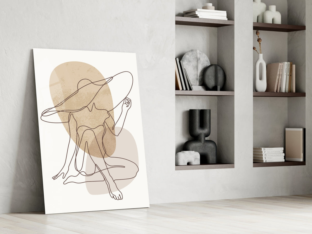 Seated woman line art glass print leaning against a white wall beside open shelves