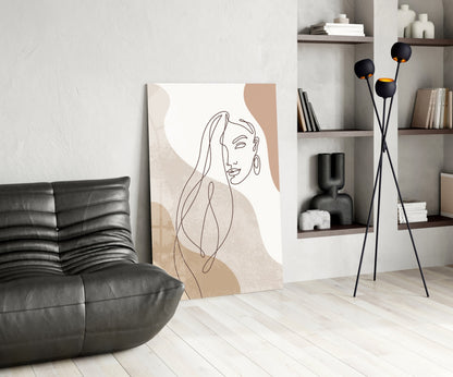 Line art woman with flowing hair glass wall art leaning beside a black leather lounge chair and open shelves