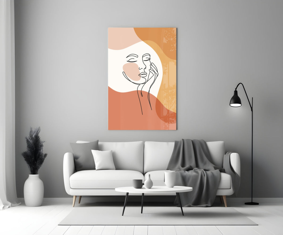 Terracotta line art face glass wall art above a white sofa beside a black floor lamp
