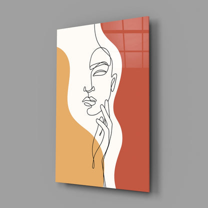Rust line art face glass wall art on a gray wall, light reflecting off the glossy front