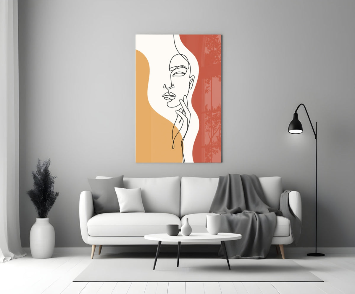 Rust line art face glass wall art above a white sofa beside a black floor lamp
