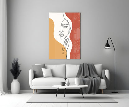 Rust line art face glass wall art above a white sofa beside a black floor lamp