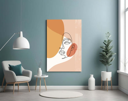 Peach line art face glass wall art on a teal wall beside a white armchair and a white pendant lamp